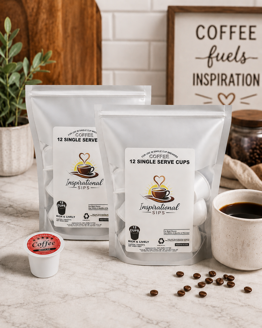 Two packages of 'Inspirational Sips' coffee with a cup of coffee and coffee beans on a table.